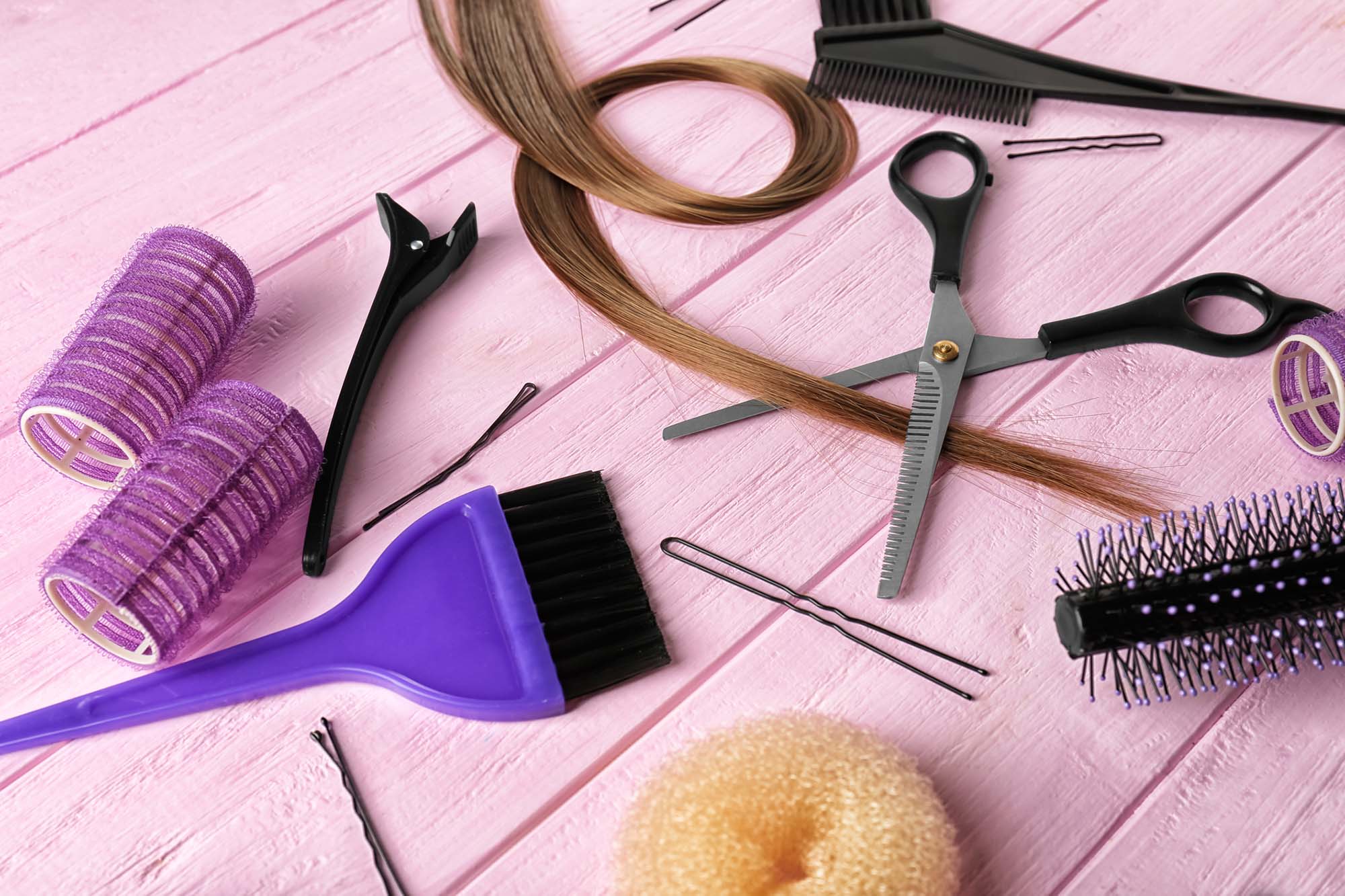 Set of hairdresser's supplies on color wooden background